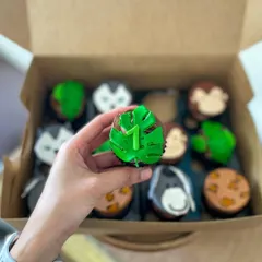 A jungle-themed cupcake for a first birthday, featuring a fondant monstera leaf and the number one.