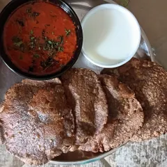 A traditional fasting meal of Vrat wali Poori made from kuttu atta (buckwheat flour), served with a simple aloo tamatar sabzi and curd.