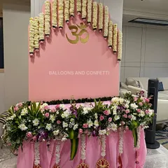 For Ganesh Chaturthi, I focus on creating a peaceful and modern space. This setup features a clean, pink arched backdrop with a golden 'Om' symbol, complemented by a cascade of fresh tuberose garlands. The base is heavily decorated with a mix of white and pink flowers, creating a serene and beautiful corner to welcome Bappa.