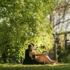 A peaceful moment shared under the shade of a large tree. This image captures a feeling of quiet intimacy and comfort, away from the hustle of the world.