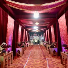 The entrance walkway was designed to feel like a royal passage. Lined with rich red drapes, patterned carpets, and elegant console tables with floral arrangements, it set a grand tone for the wedding.