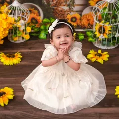 A sunny first birthday shoot with a sunflower theme. The bright yellow flowers and rustic props create a cheerful and vibrant setting.