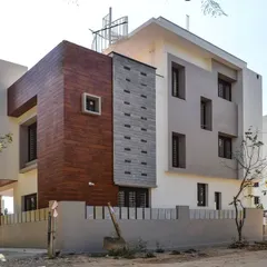 The finished exterior of a residence in Haralur, where wood-look cladding provides a warm contrast to the white and grey structure. This project shows the successful translation of a contemporary 3D design into a built reality.