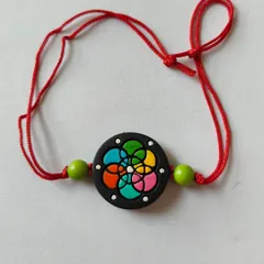 This rakhi has a vibrant, stained-glass inspired pattern on a black base. The multi-colored design is modern and cheerful, perfect for celebrating the bond with your sibling.