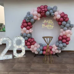 We do more than just bedrooms. This outdoor terrace setup for a 28th birthday features a custom balloon ring in a sophisticated maroon, pink, and grey palette, complete with a neon sign and large marquee lights. It’s perfect for making a big statement and creating an amazing photo corner.