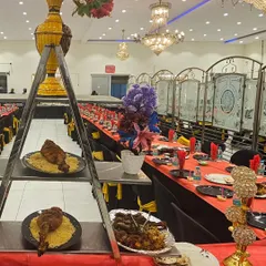 A unique presentation for a groom's table, featuring a tiered ladder stand. This setup showcases our whole roasted chicken on a bed of rice, alongside platters of our signature charcoal-grilled kebabs.