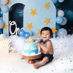 Nothing says "Happy First Birthday" like a cake smash! This little guy had the best time with his starry night themed celebration, and his joyful smile says it all.