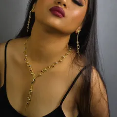 A sleek and modern gold chain necklace with matching drop earrings. This designer piece is perfect for power photoshoots or adding a bold touch to a simple outfit.
