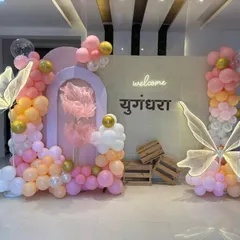 A closer view of the pastel-colored butterfly theme setup, highlighting the organic balloon garlands and wooden crate props.