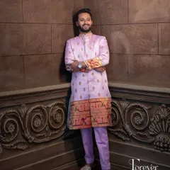 This is a full view of the Paitani silk sherwani in a unique lavender shade. The fit is tailored to be sharp and flattering, while the traditional border adds a touch of heritage and color.