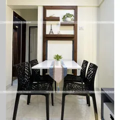 A close-up of the foldable dining table in the 1BHK apartment. When open, it provides comfortable seating for four. When folded, it becomes a decorative wall unit with shelves, demonstrating our focus on smart, functional furniture.