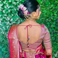A classic Maharashtrian bridal bun, beautifully adorned with fresh pink and white flowers and a traditional hair accessory. This style is elegant and timeless.
