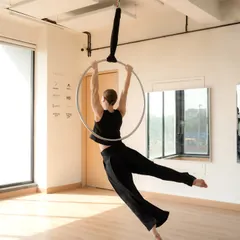 This image captures the feeling of flight on the aerial hoop. The flowing pants add to the sense of movement, showing how even simple poses can be dynamic and expressive.