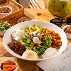 A large, healthy salad bowl with fresh avocado, chickpeas, and feta. This shot is vibrant and full of texture.