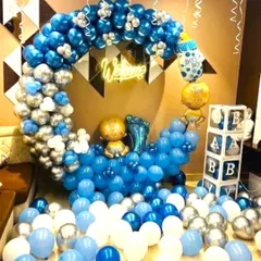 A grand baby welcome decoration in blue, silver, and white. The setup features a balloon crescent moon, 'BABY' blocks, and a 'Welcome' neon sign.