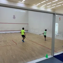 A wide view of a junior match at the Willingdon Squash Academy, showcasing the clean, professional court setup we ensure at our events.