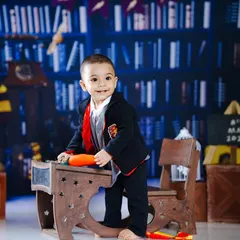 An action shot of the young wizard standing by his desk, ready to practice some spells.