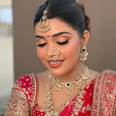 The elegance of a complete bridal set. This photo showcases a layered pearl and Polki necklace, a matching choker, intricate nose ring, and a delicate maang tikka, creating a truly unforgettable bridal profile.