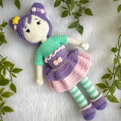 A beautiful doll with purple hair buns and a tutu dress. She also comes with a tiny backpack for her adventures. The striped stockings are attached, but her dress and shoes are removable.