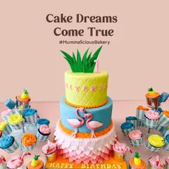 A vibrant and fun tropical flamingo cake for a first birthday. This design includes a pineapple-themed top tier, a flamingo-adorned middle tier, and a textured petal-effect bottom tier, surrounded by matching cupcakes.