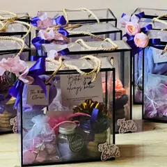 A collection of my popular bridesmaid proposal hampers. The clear acrylic boxes showcase the curated items inside, including candles, cookies, and personalized notes, all tied with beautiful ribbons.