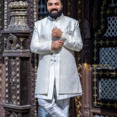 My elegant off-white sherwani features a subtle texture and a tailored fit. It's a versatile piece that provides a regal look for any traditional pre-wedding photoshoot.