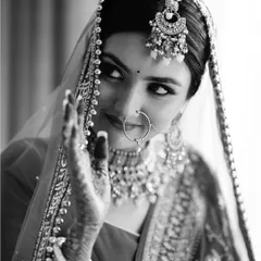 A timeless black and white portrait of the bride, her playful glance and intricate jewelry creating a captivating and classic image.