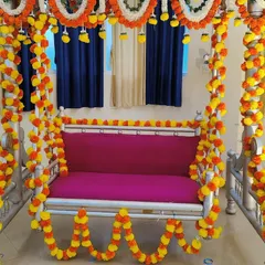 A traditional jhula (swing) decoration for a baby shower, beautifully adorned with yellow and orange marigold garlands for a classic look.