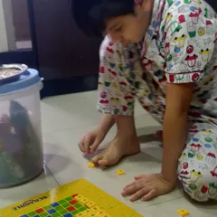 Here is my son deeply focused on his Scrabble game. This kind of play is wonderful for concentration and helps him connect the sounds of letters to written words.