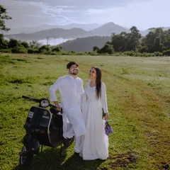 A happy, sun-kissed moment in a vast green meadow with a vintage scooter. The mountains in the background add a sense of scale and wonder.