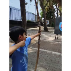 A young boy at our Dadar range, concentrating hard before his shot. This outdoor setting with palm trees is one of our most popular locations.