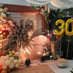 For a milestone 30th birthday, I designed this chic boho paradise at Olive Bar and Kitchen. The decor features a stunning arrangement of pampas grass, a macrame backdrop, and a warm, earthy balloon garland, perfect for a sophisticated and free-spirited celebration.