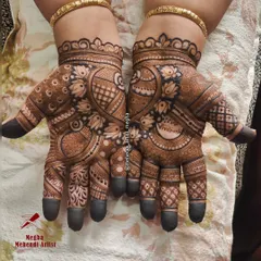 The bride's name, 'Vivanah', is elegantly written inside a circular frame on her palm, surrounded by beautiful lotus and paisley patterns.