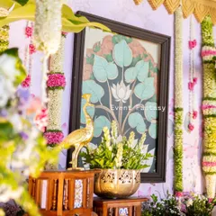 It's all in the details. This close-up from a traditional naming ceremony highlights the blend of textures and elements, from the hand-painted lotus art and brass peacock to the fresh floral garlands, all coming together to create a rich, cultural setting.