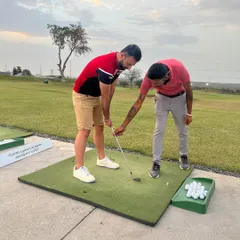 A coach provides hands-on guidance to a new player, adjusting their grip and stance to ensure they develop good habits from the start.