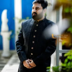 A side profile of the black textured sherwani, showing its excellent fit and structure. It's designed to look sharp from every angle.