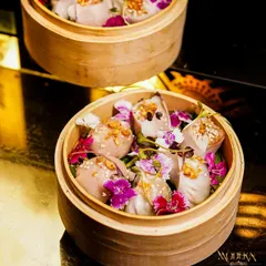 We believe food should be a feast for the eyes first. These delicate dim sum are presented in traditional bamboo steamers and garnished with edible flowers, showcasing our commitment to artistic food presentation and pan-Asian cuisine.