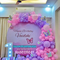 A magical butterfly theme for Vaidehi's first birthday. The pink and purple balloon garland is accented with butterfly stickers and paired with a light-up number '1'.