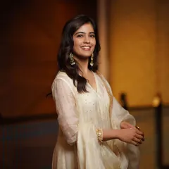 Capturing a moment of pure, natural joy. The subject's bright smile is the centerpiece of this portrait, complemented by the soft elegance of her white ethnic suit.