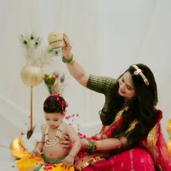 A playful interaction during our Janmashtami session. The mother holds up a pot of 'makhan' for her little Krishna, creating a classic and adorable photo.