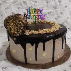 A classic combination of chocolate and almond, this drip cake is a crowd-pleaser. It features a rich chocolate drip, crunchy chopped almonds, and golden Oreo cookies for decoration.