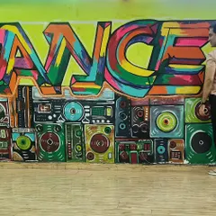 This colorful graffiti wall is the heart of my studio. It represents the energy, passion, and vibrant spirit of dance that I want to share with every student who walks through the door.