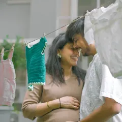 A sweet, intimate moment captured during our baby clothesline themed shoot. The tiny outfits in the foreground are a lovely symbol of the future they are building together.