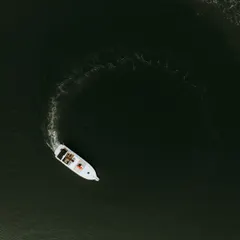 An artistic aerial shot of a couple's boat creating a perfect circle on the water in Goa. This kind of unique perspective is what I strive for in a pre-wedding shoot.