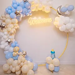 This 'A Sky Full of Stars' theme is perfect for a magical welcome home. We used a modern circular gold frame adorned with a cloud-like balloon garland in pastel blue, white, and cream, complete with a glowing 'Welcome' neon sign and silver moon and star accents.