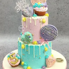 Welcome to Candyland! This vibrant, three-tiered non-fondant cake is a dream for anyone with a sweet tooth. We used a colorful drip effect and adorned it with handmade lollipops, cupcakes, and geometric hearts for a fun, whimsical look perfect for a big birthday bash.