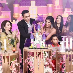 A grand celebration with the entire family. This shot captures the excitement of the cake cutting, complete with confetti and applause, at an elaborate princess castle themed party.