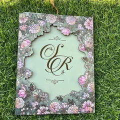The beauty is in the details. This design features an intricate floral laser-cut frame on a soft sage green, revealing a custom monogram that tells your unique love story. It’s a piece of art that your guests will treasure.
