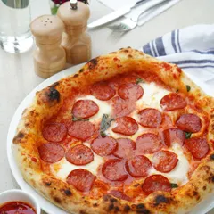 Behold our signature Napoletana-style pepperoni pizza. We use premium Swiss flour for a light, airy crust and a rich sauce made from San Marzano tomatoes, topped with authentic pepperoni and fresh mozzarella for a truly gourmet pizza experience.