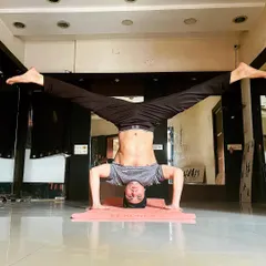 From the tripod headstand, I demonstrate a wide-legged variation, which challenges balance and hip flexibility.